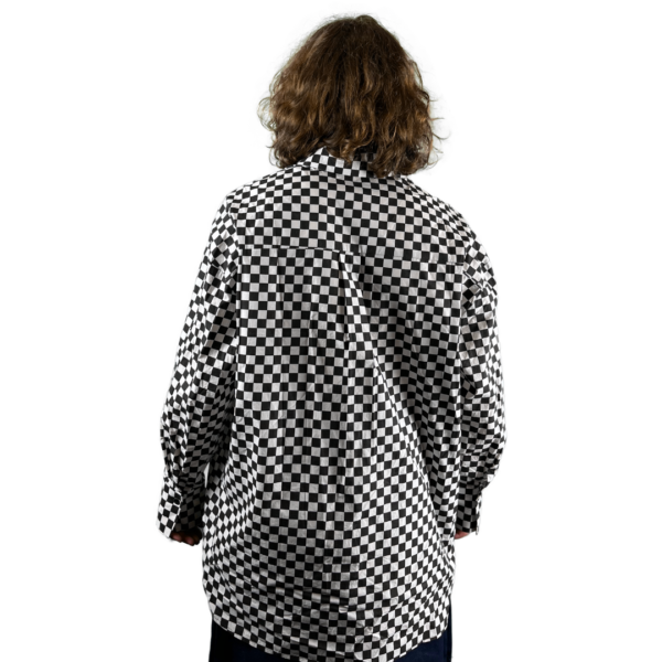 A person with shoulder-length curly hair, viewed from the back, wearing a checkered shirt against a white background.